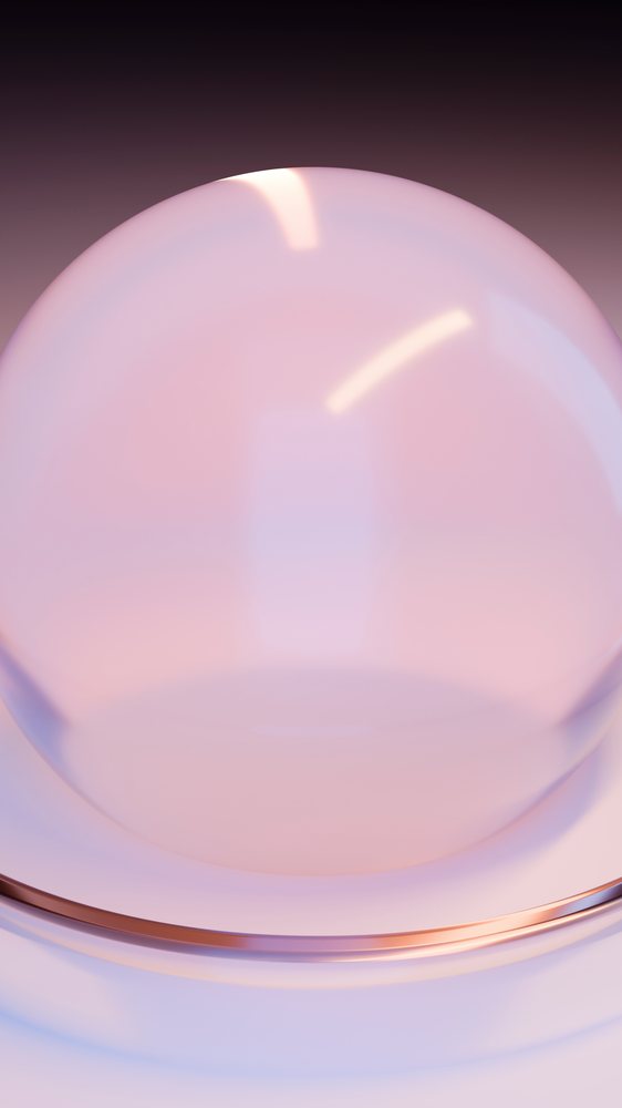 Close-up of a reflective glass dome with pink tint on a smooth surface in a minimalist studio setting.