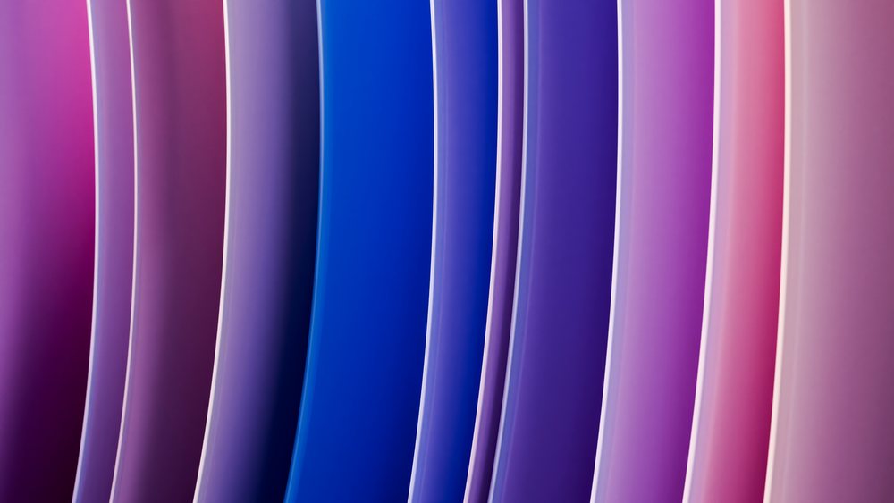 Digital art features colorful vertical abstract curves in blue, purple, and pink gradients forming a smooth flowing pattern.
