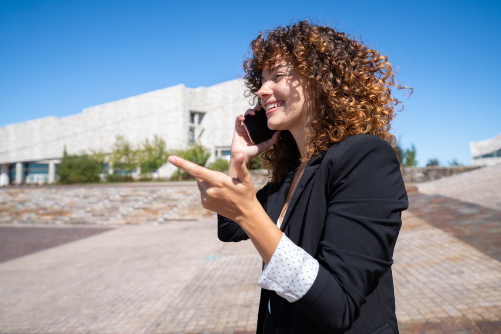 Businesswoman talking on phone and smiling outdoors in Santiago de Compostela, traveling executive, Spain, Antiago De Compostela.