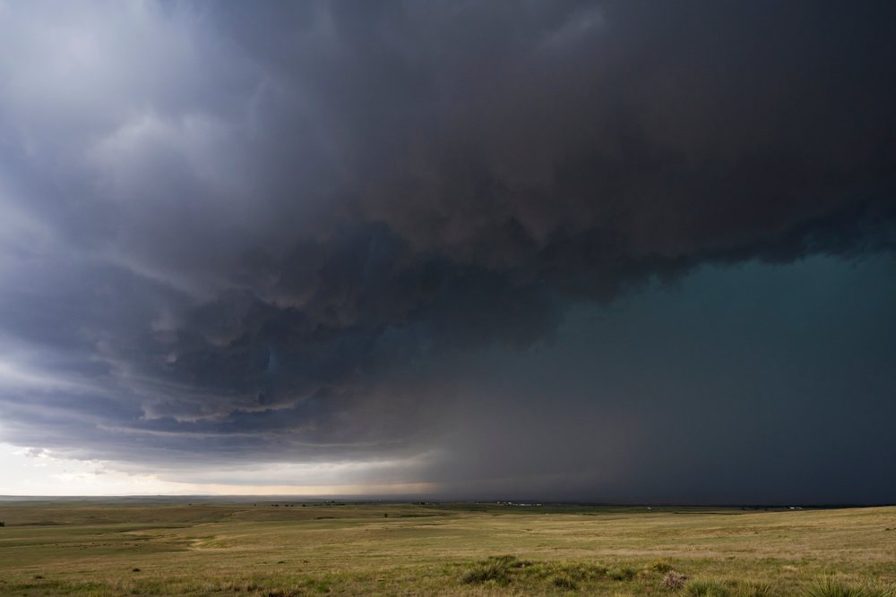 Dark storm clouds gather over an open grassy field as a storm front approaches, Storm Chasing, Weather, Environmental Issues, Agate, Colorado, USA.