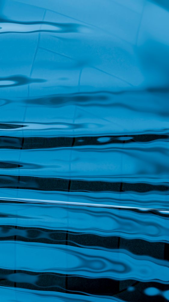 Blue abstract background featuring fluid ripple patterns and horizontal wave-like undulations with reflective liquid surface.