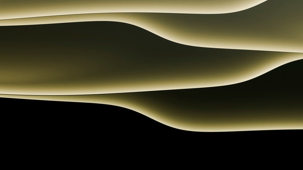 Abstract curved illuminated wall with soft flowing light and shadow patterns in a modern architectural design.
