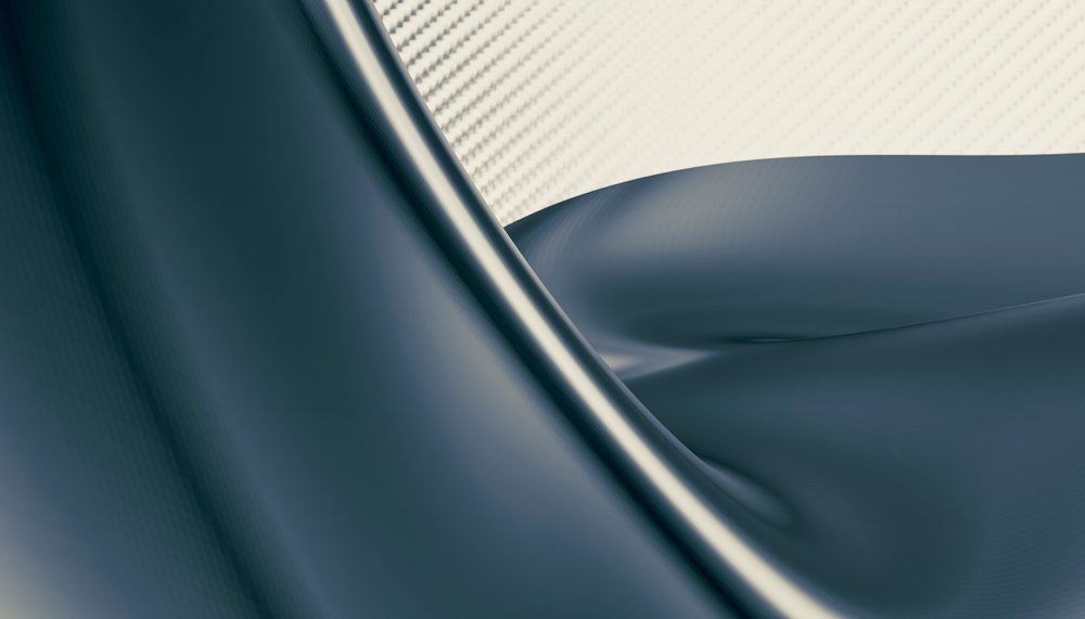Close-up view of dark silky fabric draped over white fabric background showing smooth folds and texture.