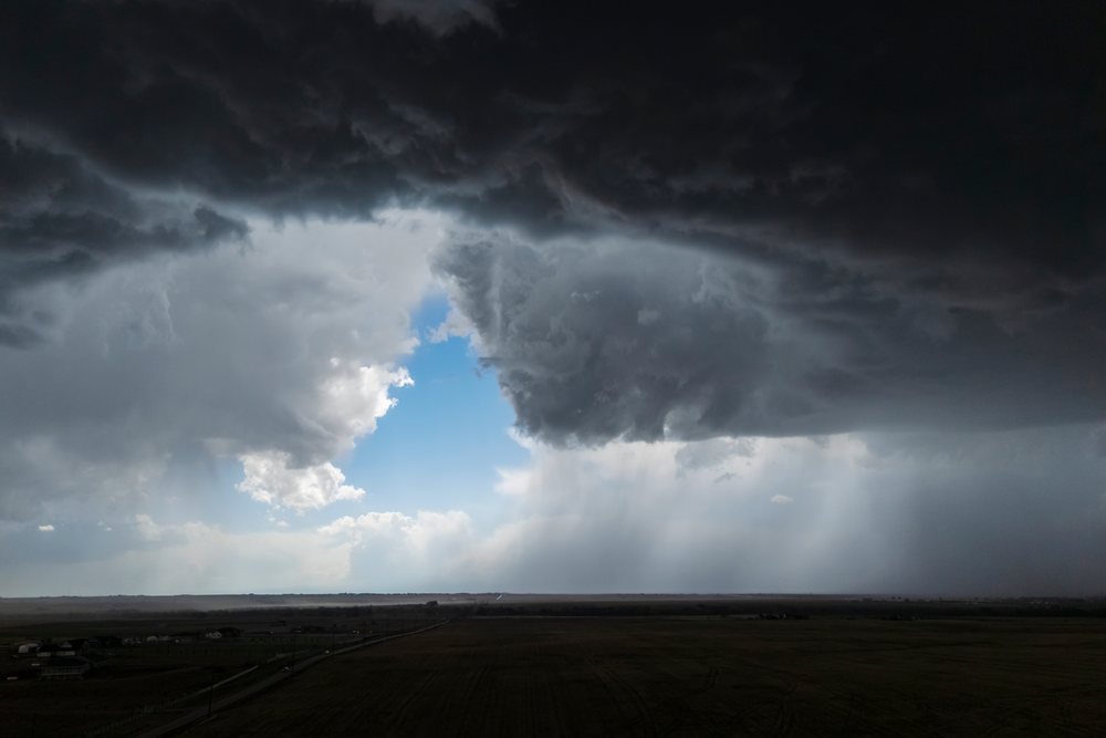 Rear flank downdraft storm cloud with visible rain shafts over open agricultural fields, Storm Chasing, Weather, Environmental, Byers, Colorado, USA.