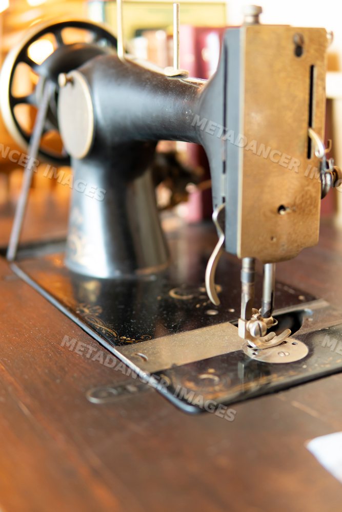 Close-up of a vintage sewing machine on a wooden table