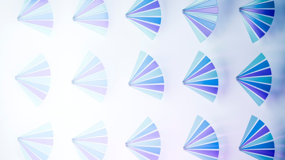 Abstract illustration featuring repeated blue and purple fan shapes arranged symmetrically on a light background.
