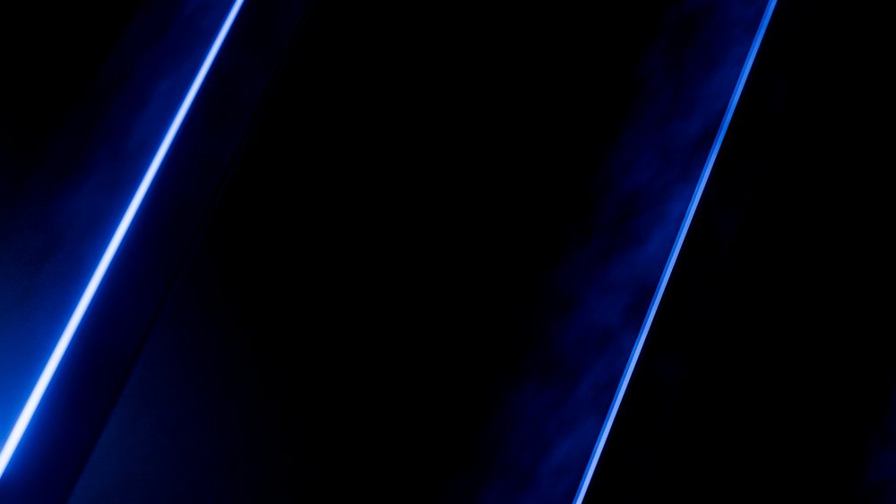 Blue neon lights form two diagonal glowing lines on a dark background creating a modern abstract effect.