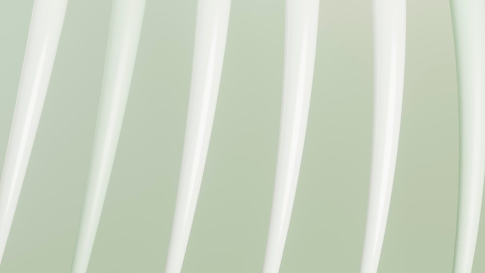 Close-up of white metal fork prongs against a soft green background.