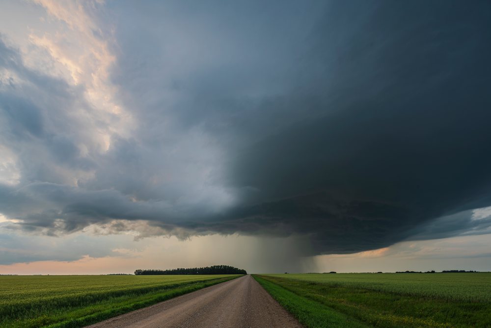Storm supercell with low precipitation dark clouds over farmland and a dirt road, Storm Chasing, Weather, Environment, Rocky View County, Saskatchewan, Canada.