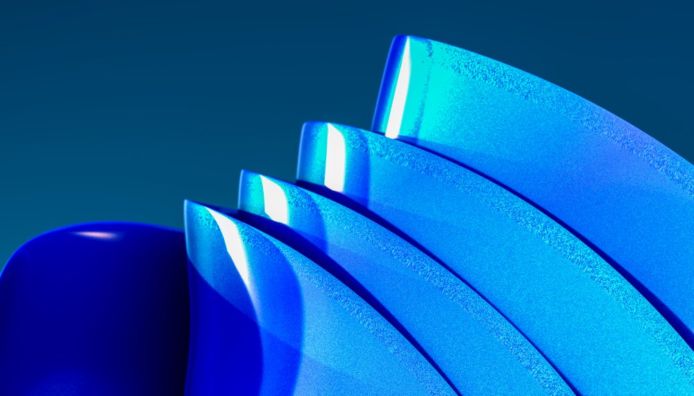 Blue curved abstract shapes with shiny textured surfaces and gradient background in studio lighting.