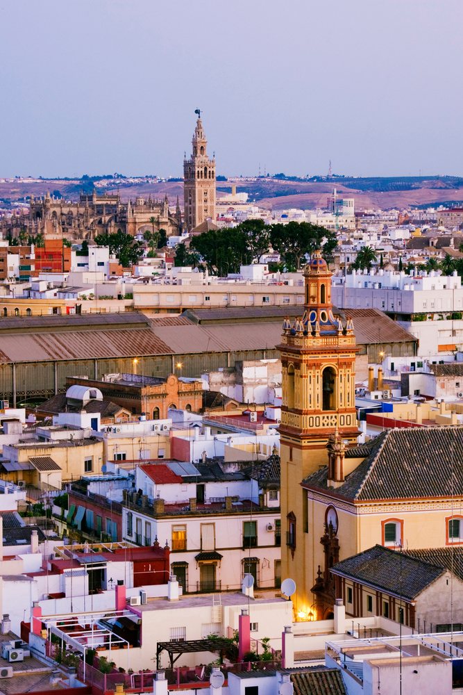 Historic towers and Mediterranean architecture define the urban cityscape of Seville, at sunset, Andalucia, Spain.