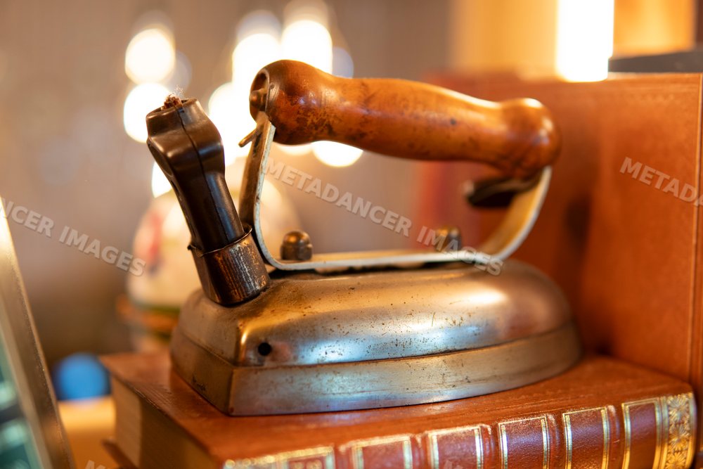 Close-up of a vintage iron with wooden handle on books in Verdun