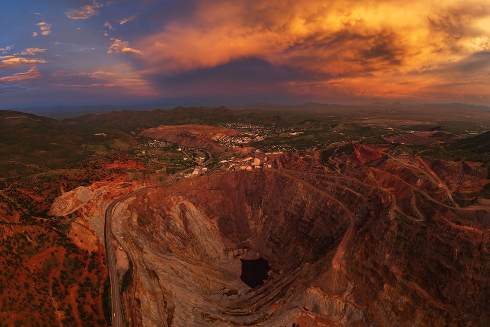 Large open pit mine with red soil under stormy sunset sky, Storm Chasing, Weather, Environment, Canada, USA.