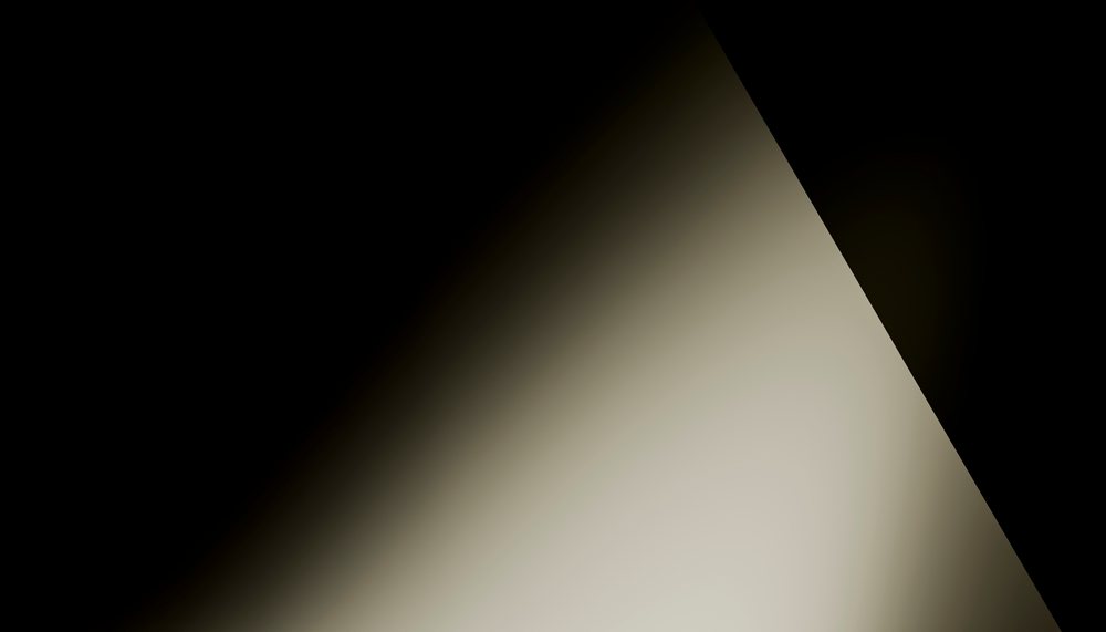 Abstract diagonal light gradient fading into darkness creating a minimalist and dramatic effect.
