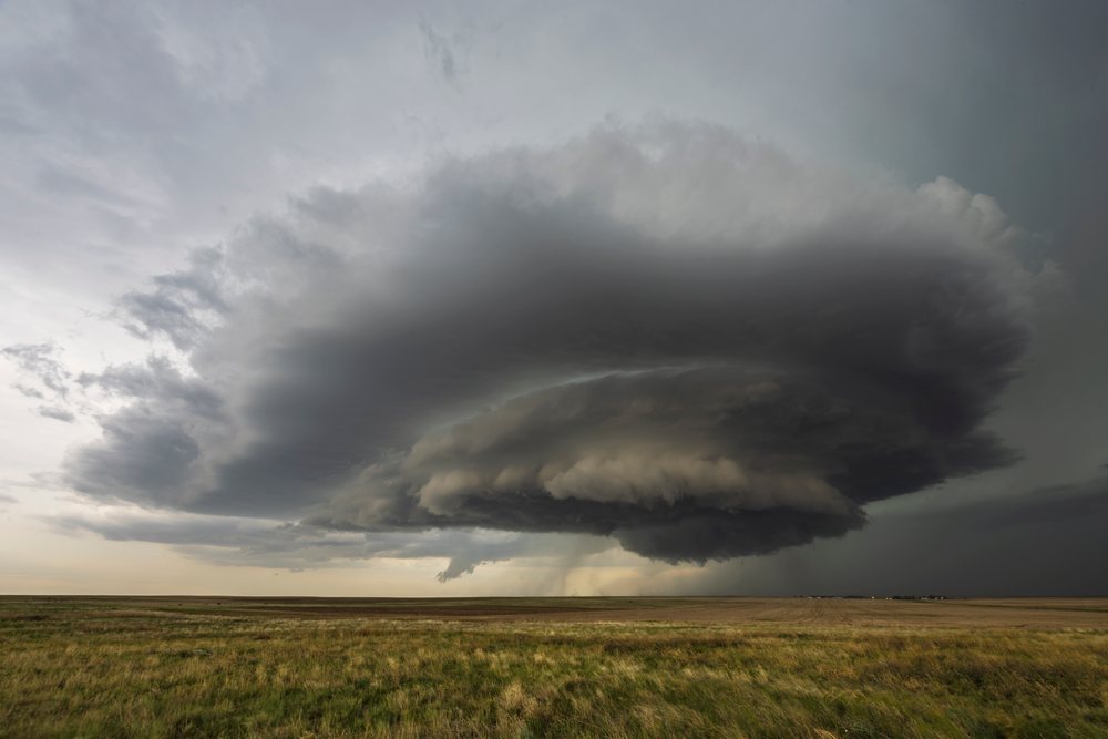 Mesocyclone storm forming above grassland plains during storm chasing in Tornado Alley, Merino, Wyoming, USA.
