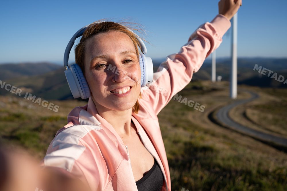 White Woman taking a selfie with wind turbines