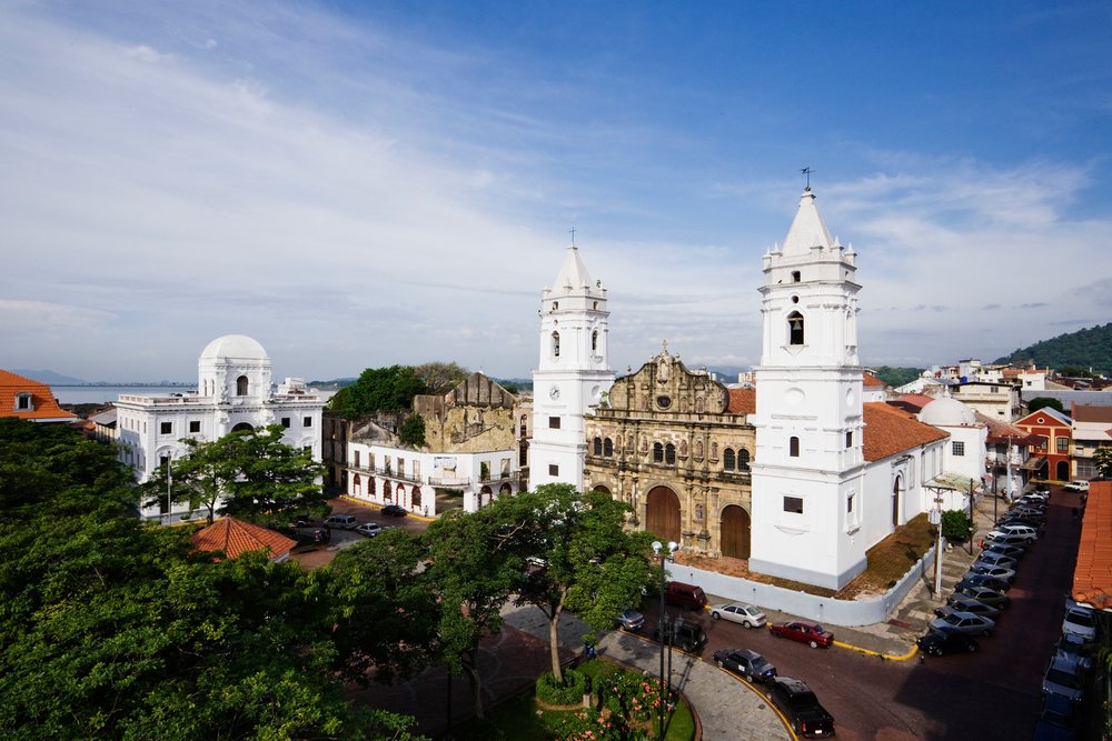 Cathedral with twin white towers in the historic Casco Viejo district of Panama City, under a blue sky.