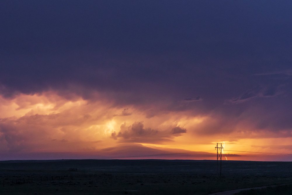 Shelf Cloud and lightning strike at sunset over an open field in Tornado Alley, Storm Chasing, Alzada, Montana, USA.