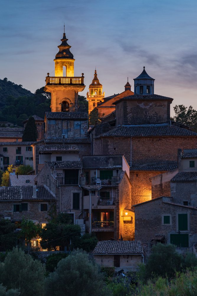 Valdemossa village skyline lit by warm lights at dusk, Landscape, Lifestyle, Mallorca, Spain.