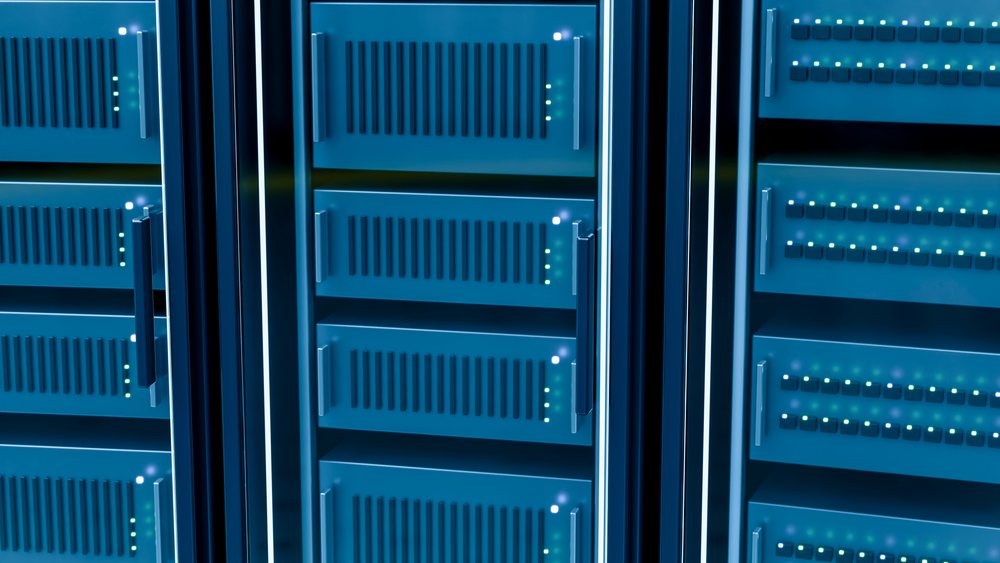 Close-up of multiple server racks with LED indicator lights and ventilation slots in a blue-lit data center room.
