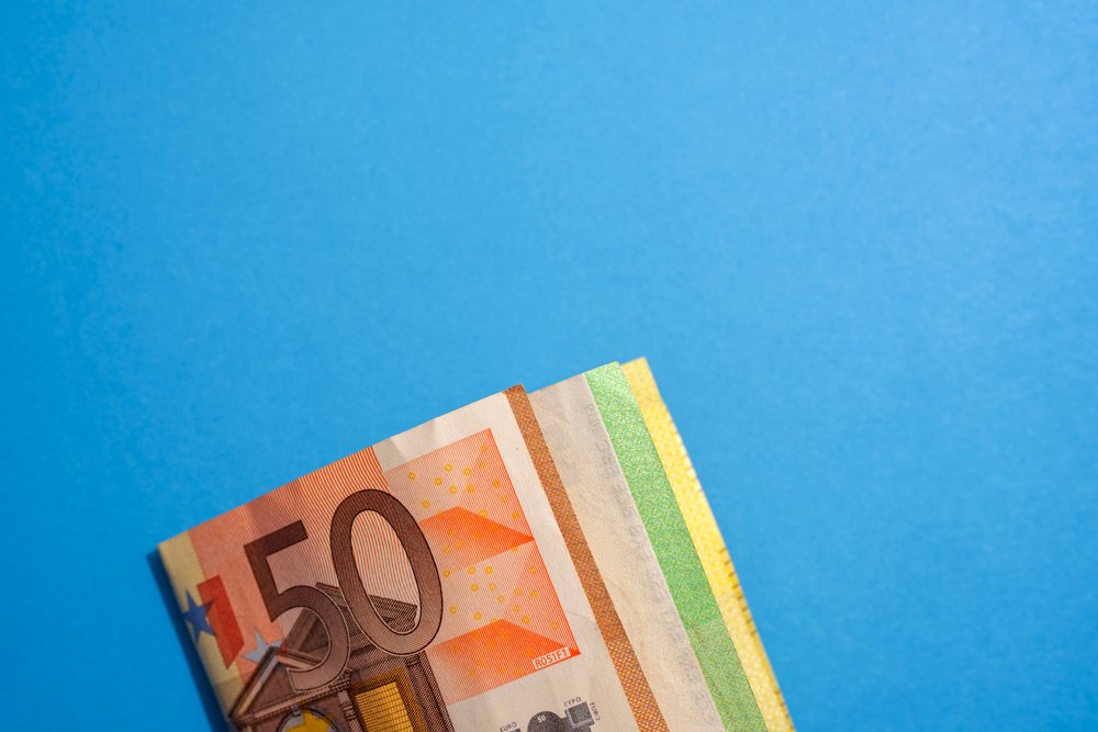 Folded euro banknotes on a blue studio background representing currency and financial concepts, Studio Shot.