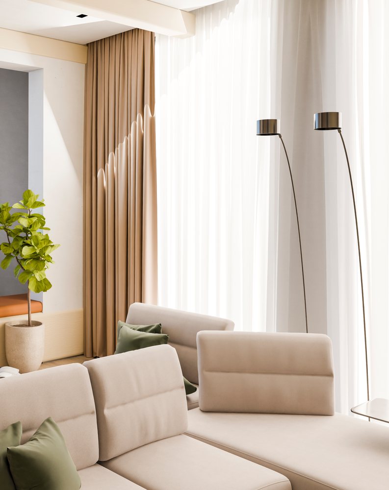 Modern living room features a beige upholstered sofa with green pillows, flanked by two floor lamps and a large leafy indoor plant.