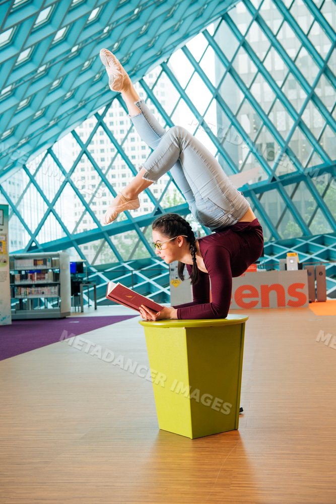 A woman balances in a contortionist pose while reading in a Seattle