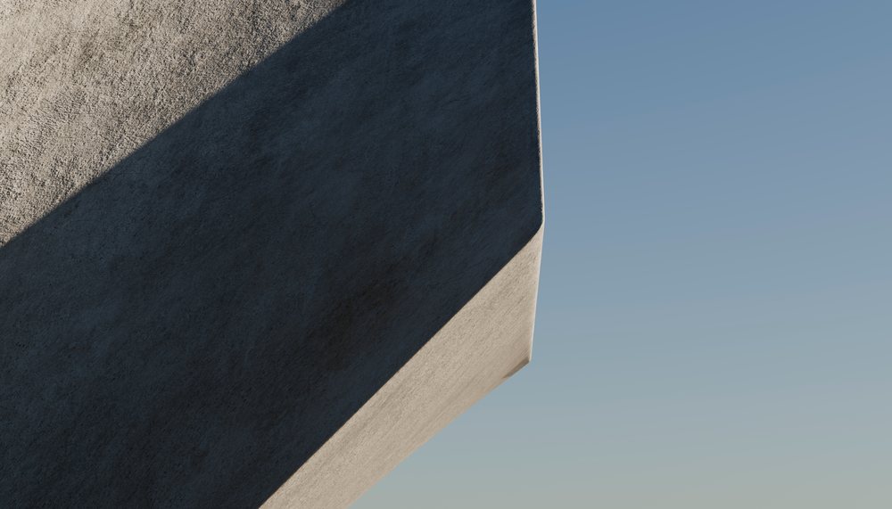 Close-up of a concrete building corner casting shadow under blue sky