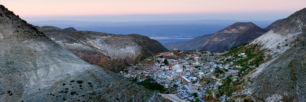 Sunset over the village of Real de Catorce nestled in a mountain valley with rocky hills and arid natural vegetation, San Luis Potosi, Mexico.