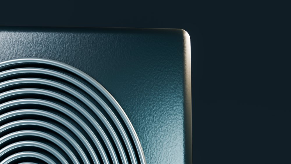 Close-up of an electric stovetop coil heating element against a dark background.