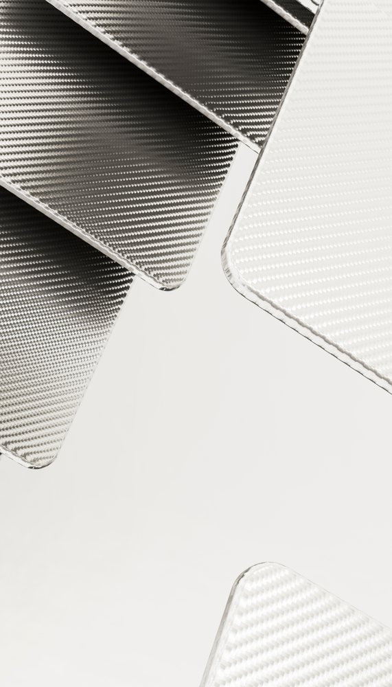 Close-up view of black and white woven carbon fiber textile showing detailed weave pattern and texture.
