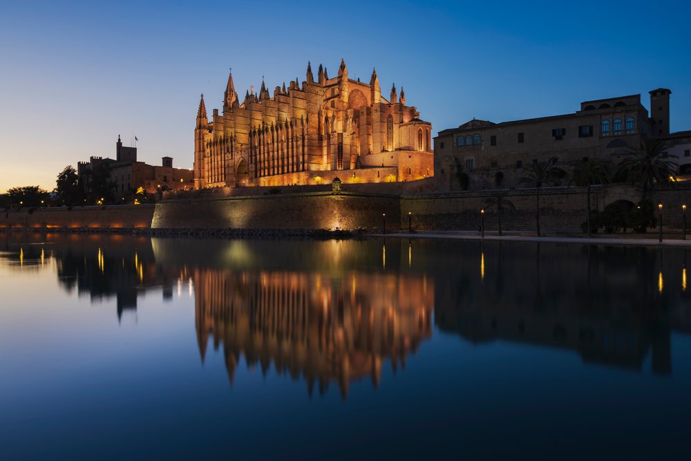 Mallorca Cathedral at Dusk is illuminated with its reflection shimmering on calm water, Landscape, Lifestyle, Palma de Mallorca, Balearic Islands, Spain.