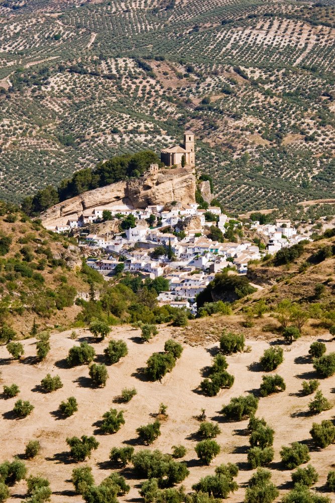 Montefrio village with white houses and a church atop a rocky hill, Andalucia, Spain.