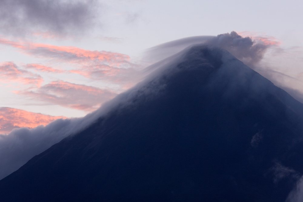 Arenal Volcano emits smoke clouds at dawn over the mountain peak, Costa Rica.