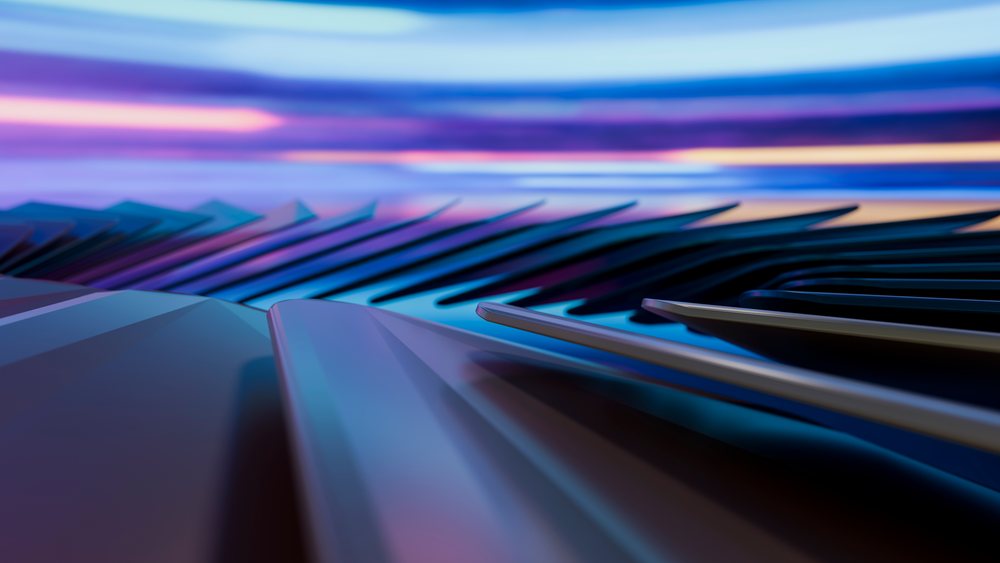 Close-up of black and white piano keys reflecting colorful lights creating an artistic musical atmosphere in a studio.