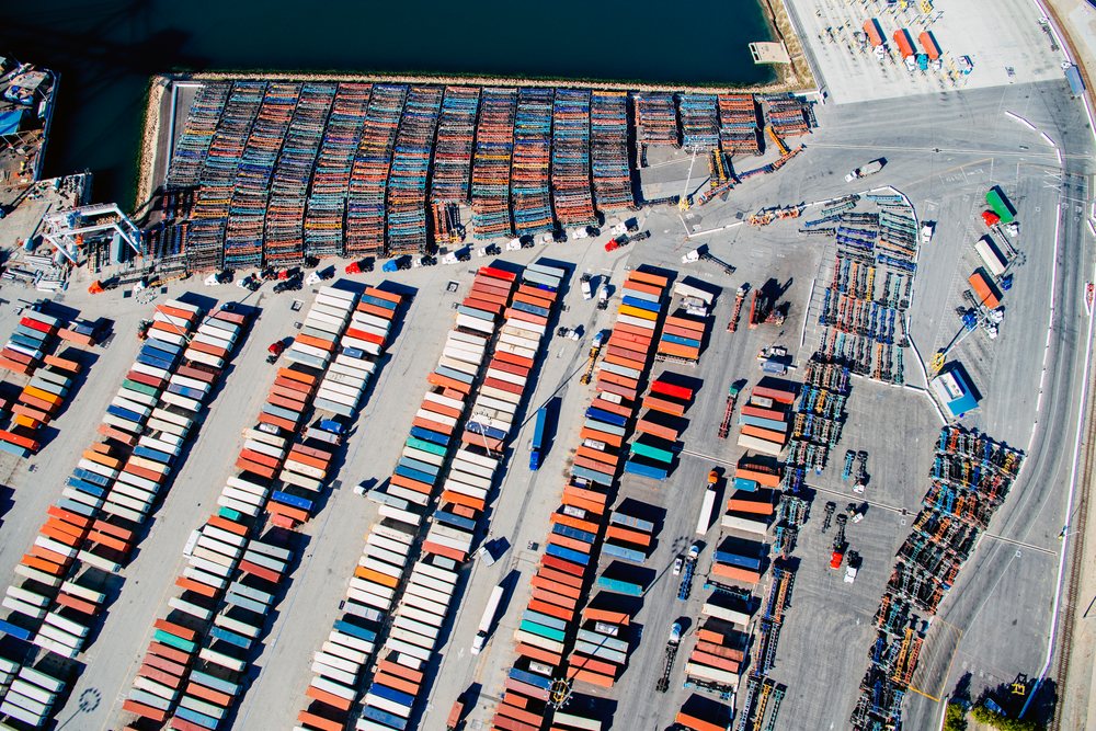 Aerial view of a container terminal with rows of shipping containers, trailers, cranes, and trucks at the, Port of Long Beach, CA, USA.