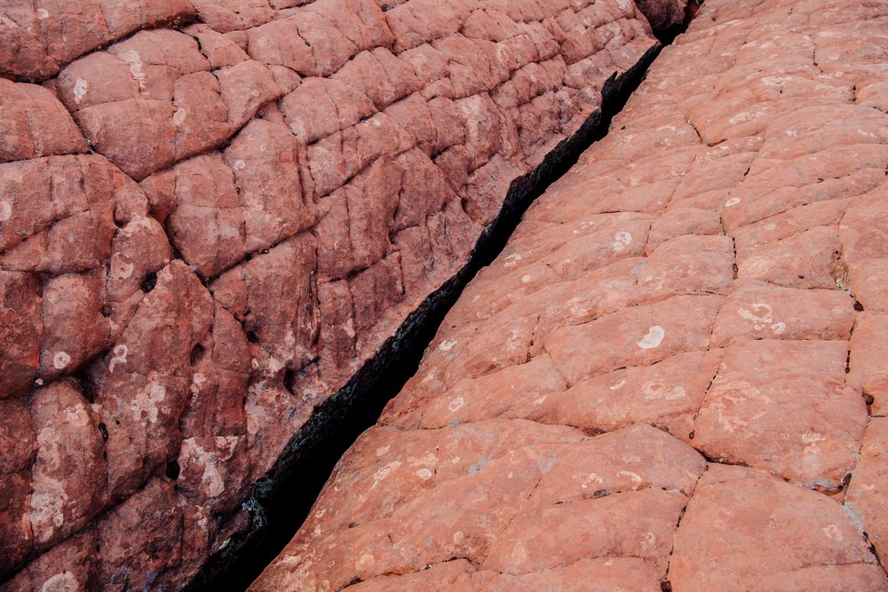 Red rock formation with a deep crack in the rugged desert terrain of a State Park, Snow Canyon, red Cliffs Desert, Utah, USA.