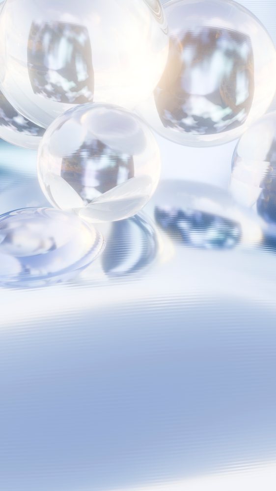 Multiple transparent glass spheres rest on a smooth reflective surface with light reflections and soft shadows in a minimalist studio setting.
