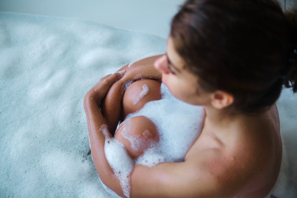 A woman enjoys a bubble bath for relaxation and cleansing in a bathtub in the, Maldives.