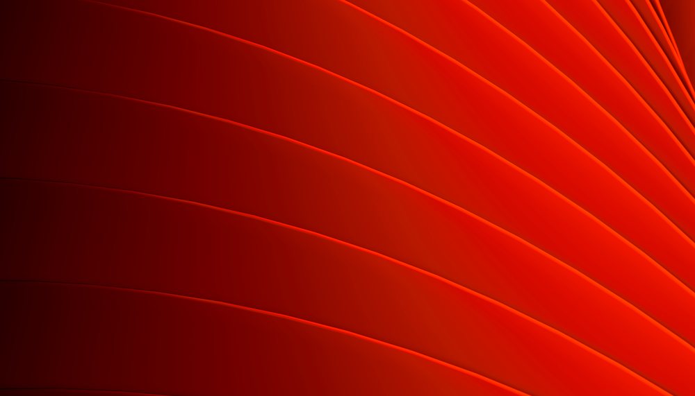 Abstract red and orange geometric pattern with smoothly curved lines forming a flowing, bright gradient design.