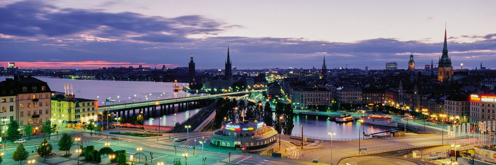 Stockholm city skyline at dusk with illuminated bridges, historic buildings, and reflections on the water, Dusk Stockholm, Sweden.