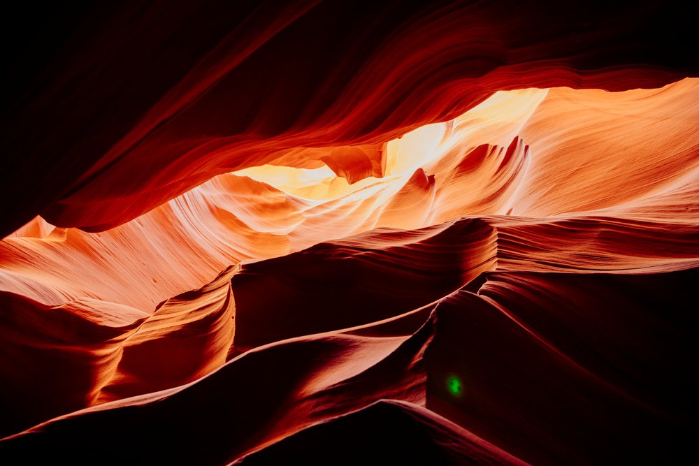 Sunlight illuminates smooth sandstone rock formations of Antelope Canyon, Arizona's natural slot canyon landscape, Navajo Land, USA.