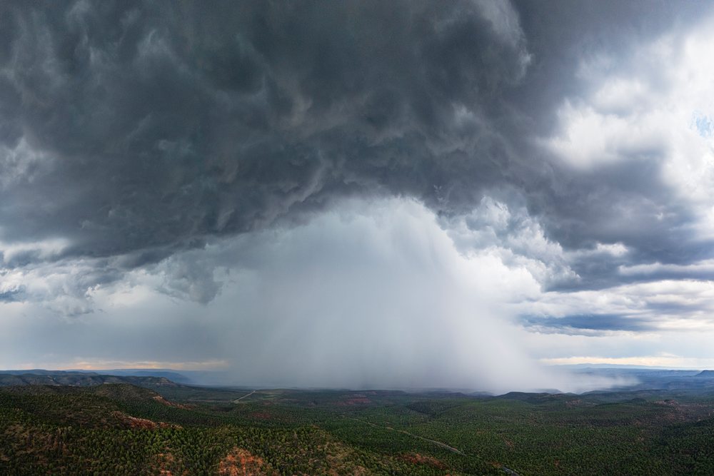 Rain shaft Downburst occurs beneath collapsing monsoon thunderstorm clouds over forested hills and mountains, Storm Chasing, Weather, Environment, Carrizo, Arizona, USA.
