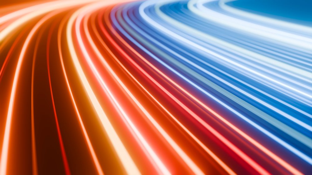 Abstract curved light trails in red, orange, white, and blue form a dynamic, vibrant pattern in motion.