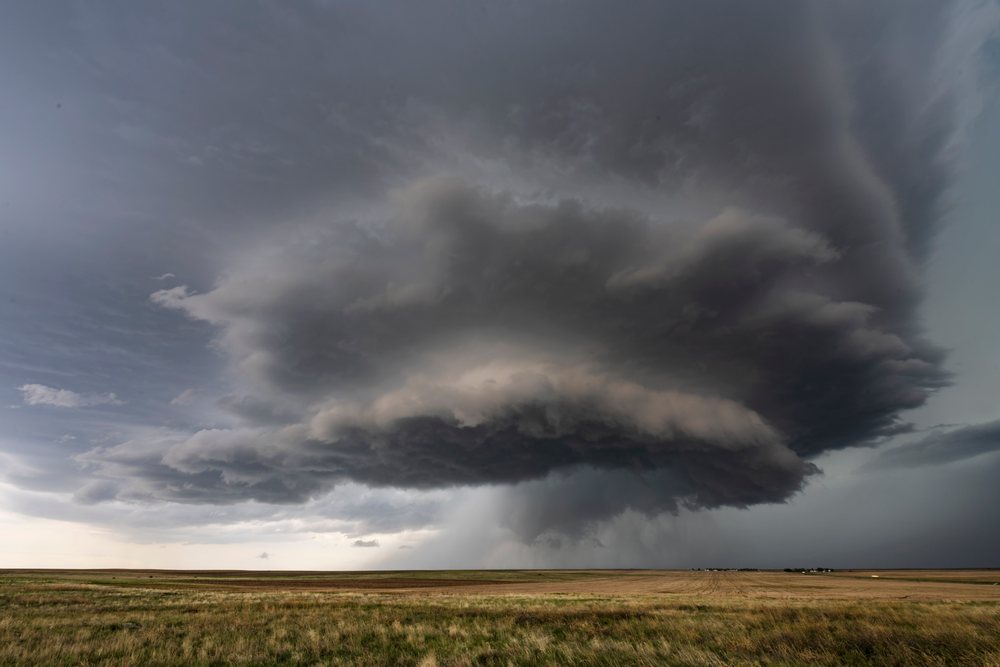 Supercell storm with dark rotating clouds and rain shaft over grassy plains, Merino, Colorado, USA.