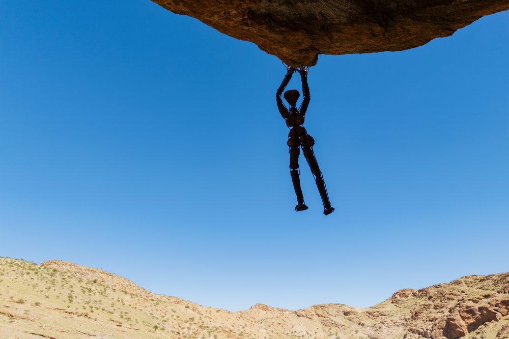 Rock Man wire sculpture hanging from a boulder in the arid landscape of Damaraland, Kunene Region, Namibia.