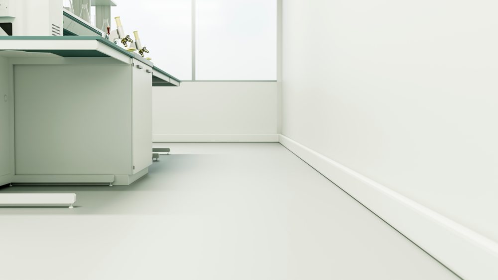 Clean, modern laboratory workbench holds microscopes in a bright white research room.