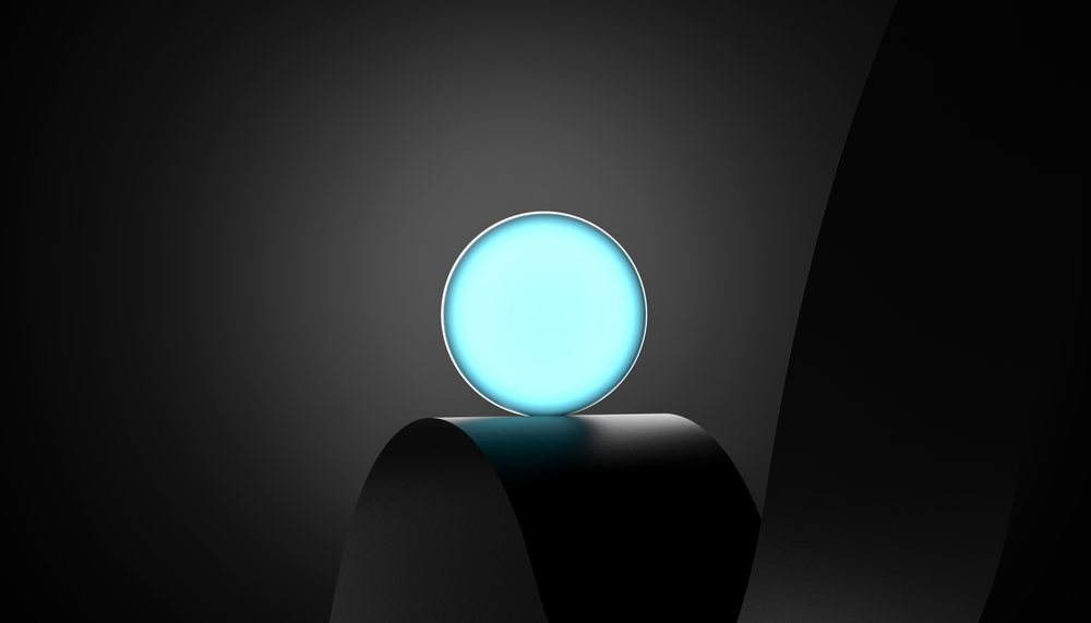 A blue glowing spherical light is illuminated on a black curved surface against a dark background.