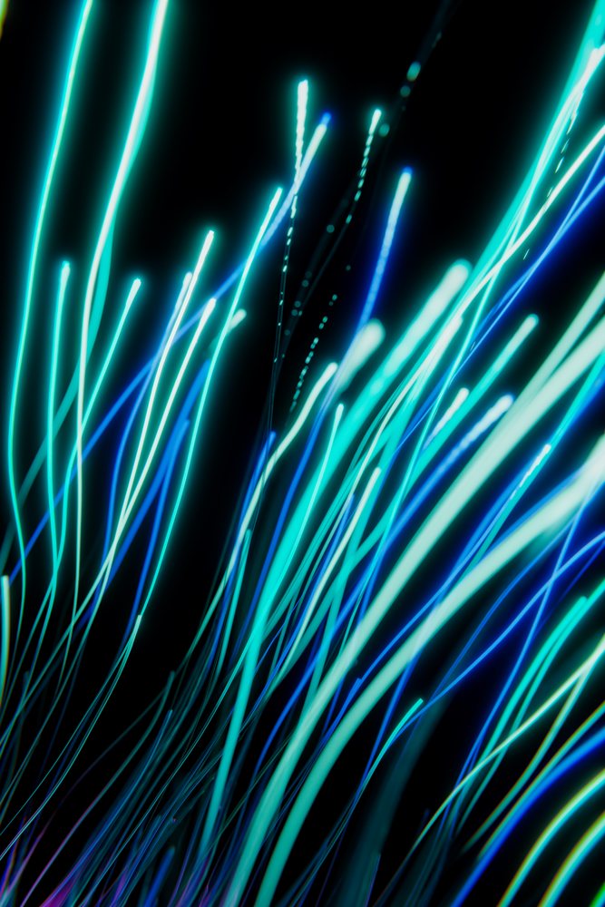 Glowing blue and teal abstract light streaks creating a dynamic digital art rendering on a dark background.
