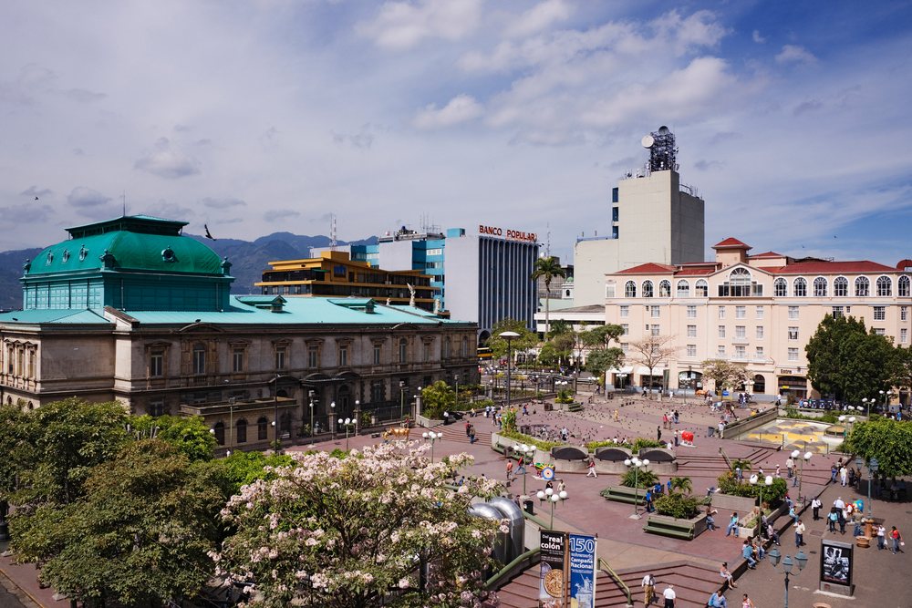 Plaza de la Cultura, with the National Theatre and people enjoying the public square on a clear day, San Jose, Costa Rica.